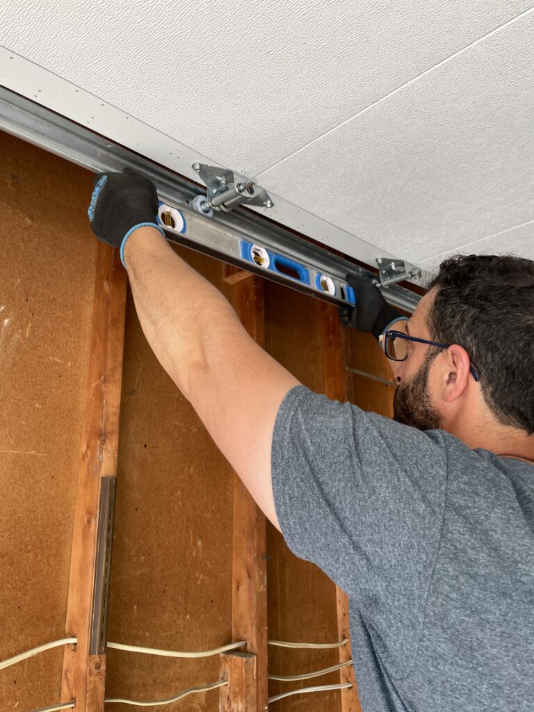 Penguin Garage Doors technician aligning and adjusting garage door tracks for smooth garage door operation in Thornhill.