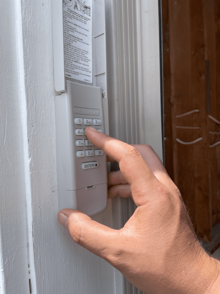 Penguin Garage Doors technician connecting a LiftMaster garage door keypad to a garage door opener for smart access installation in Vaughan.