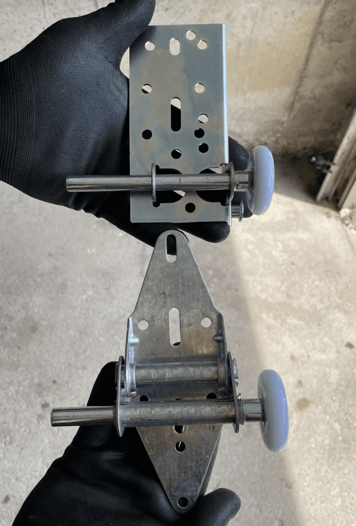 Garage door bottom bracket with roller and garage door hinge with roller, highlighted for garage door roller and hardware replacement services by Penguin Garage Doors in Markham.