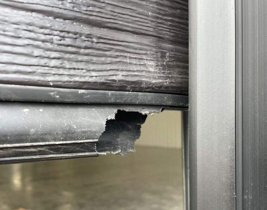 Damaged garage door bottom seal chewed by pests. In need of garage door bottom seal replacement by Penguin Garage Doors in Vaughan.