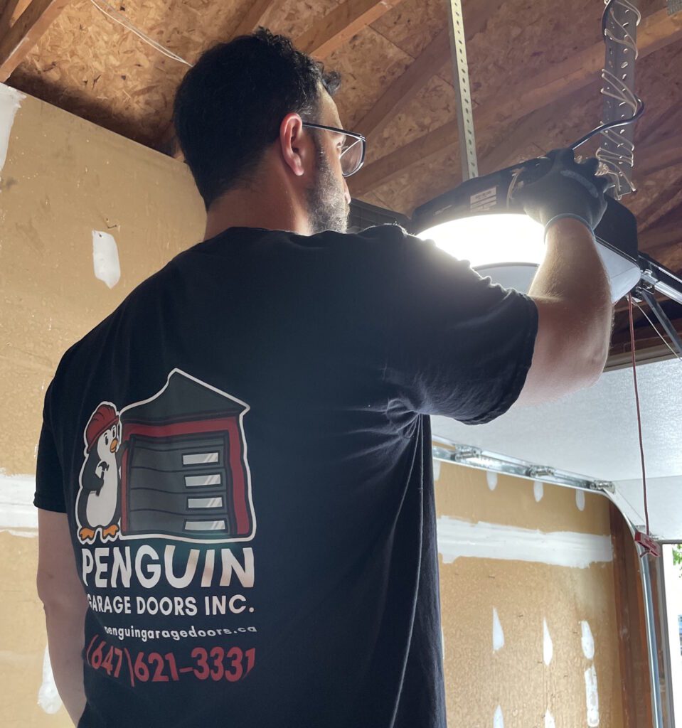 Penguin Garage Doors technician completing the installation of a garage door opener in Thornhill.