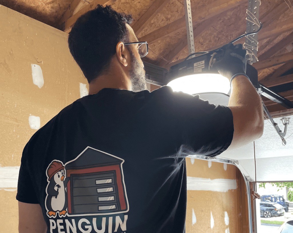 Penguin Garage Doors technician installing a new smart Chamberlain garage door opener in Toronto.