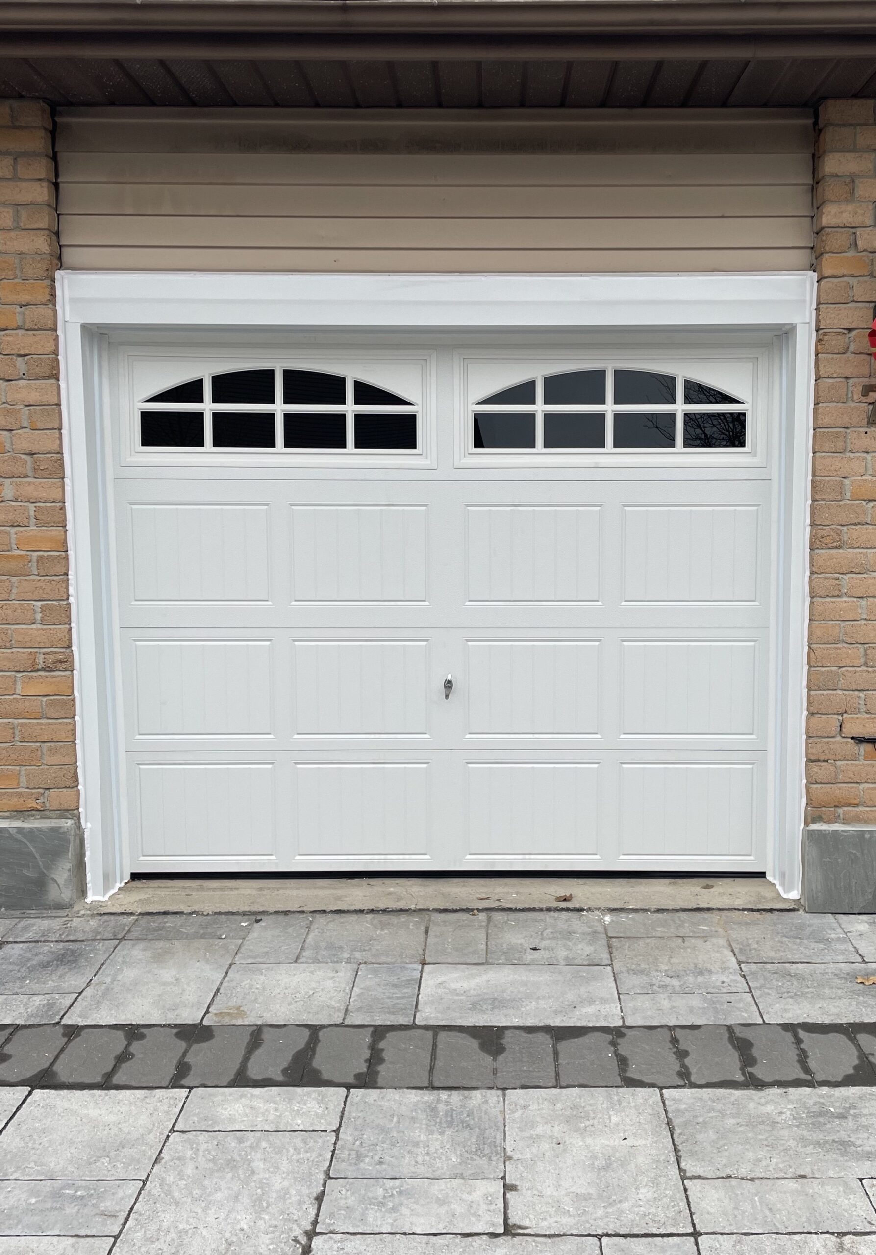 Penguin Garage Doors freshly installed traditional white grooved panel single garage door with windows for enhanced curb appeal and home style.