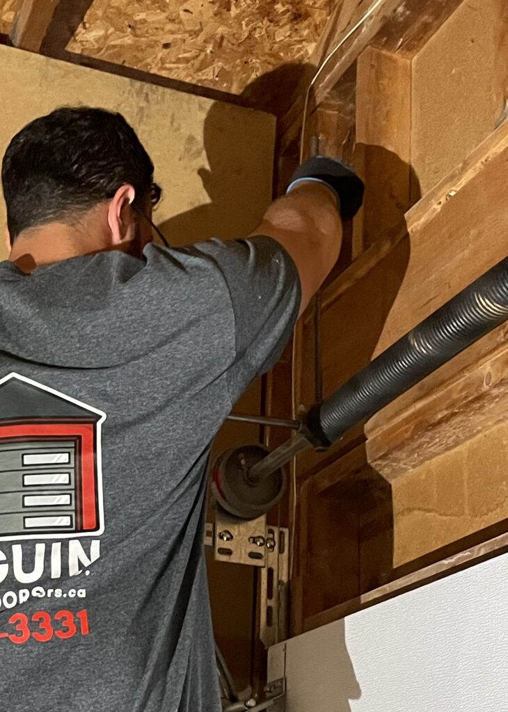 Penguin Garage Doors technician performing garage door spring repair to restore safe and reliable operation.