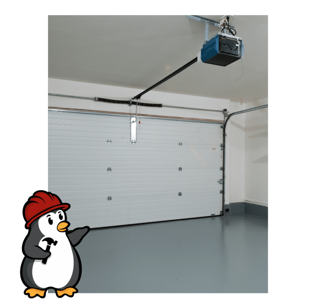 Penguin Garage Doors logo with cleared garage door space prepared for professional new garage door installation.